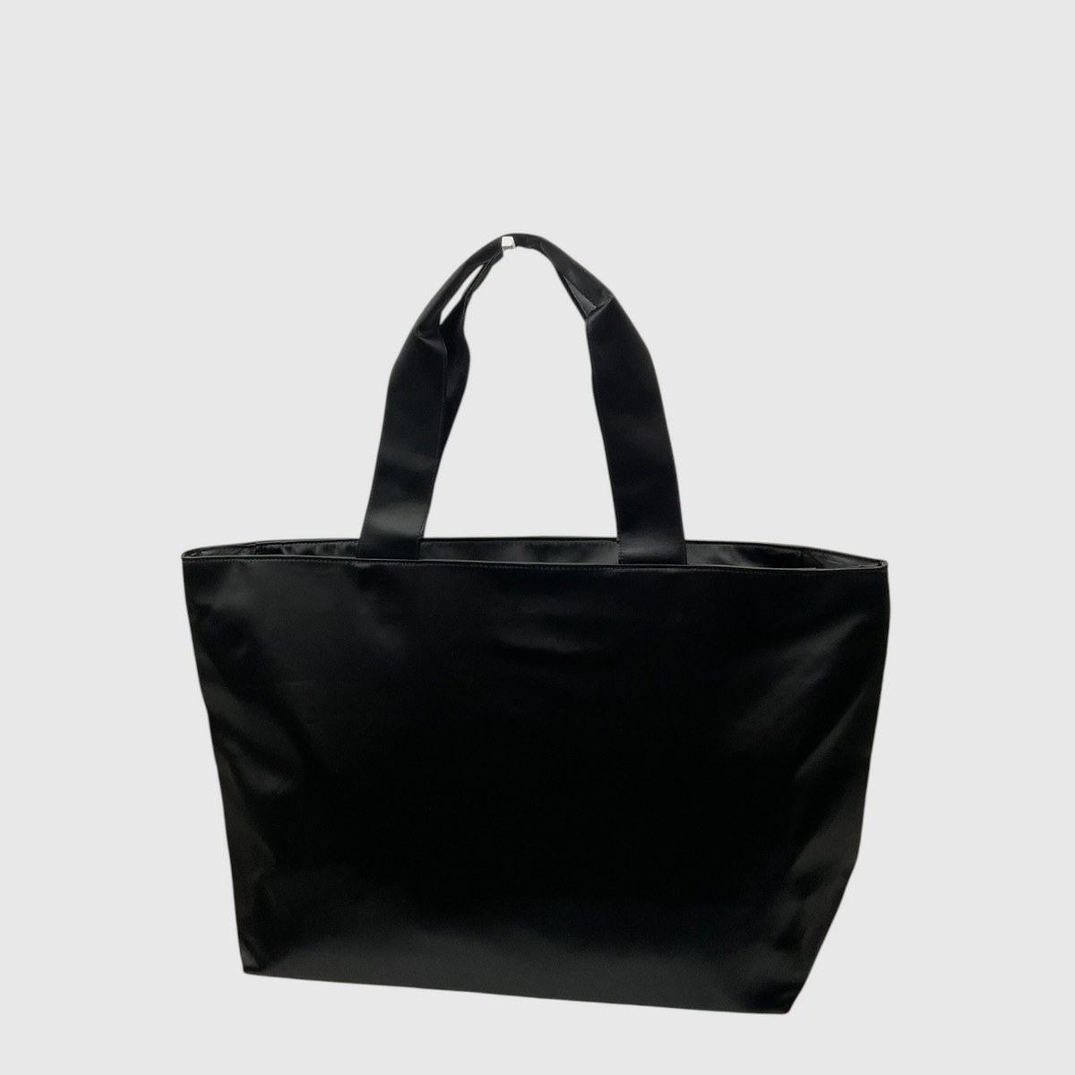 A black fabric tote bag with two shoulder straps, photographed against a solid light gray background.