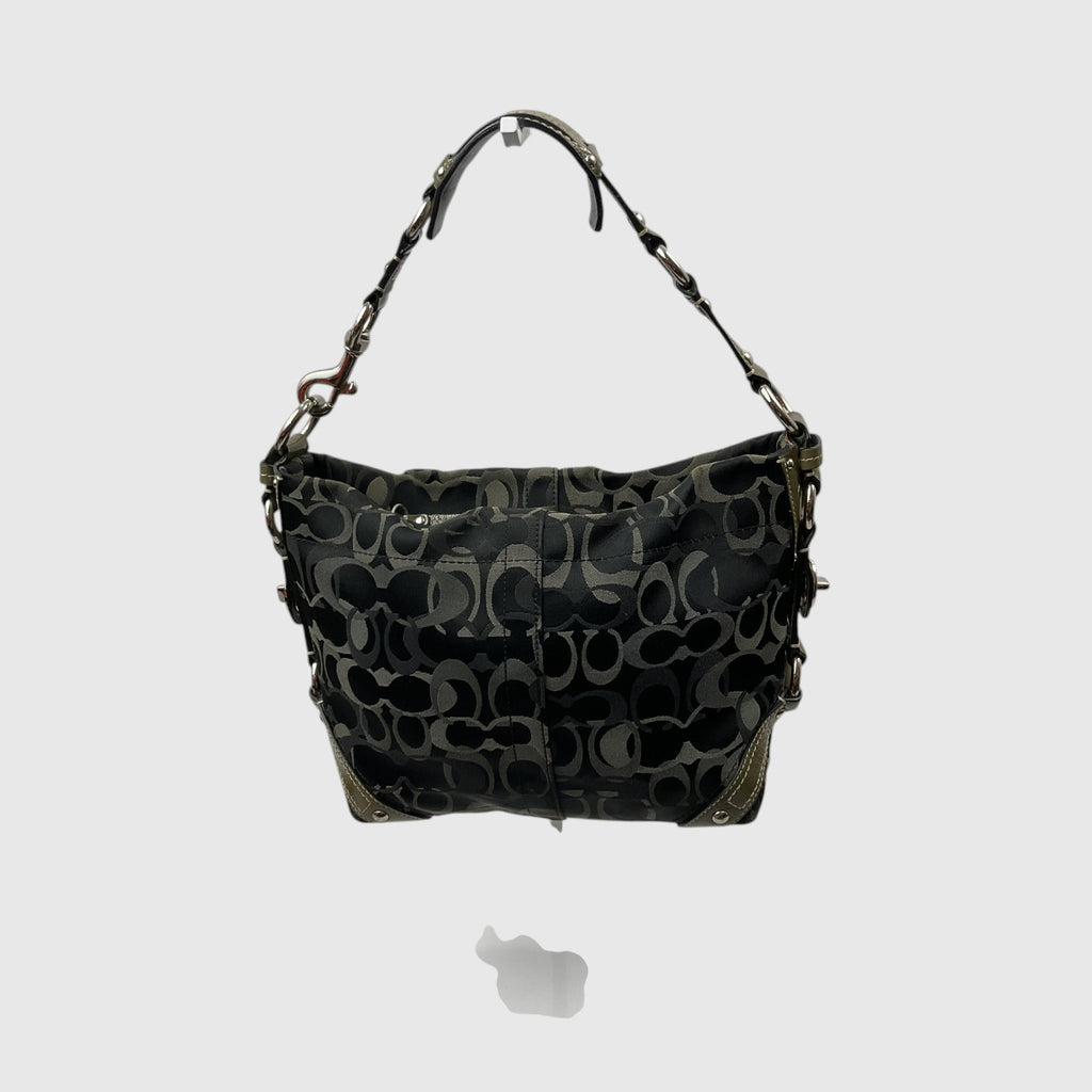 A Coach hobo shoulder bag in black coated canvas with the signature monogram logo pattern in dark gray and black, featuring gold-tone hardware and a matching shoulder strap.
