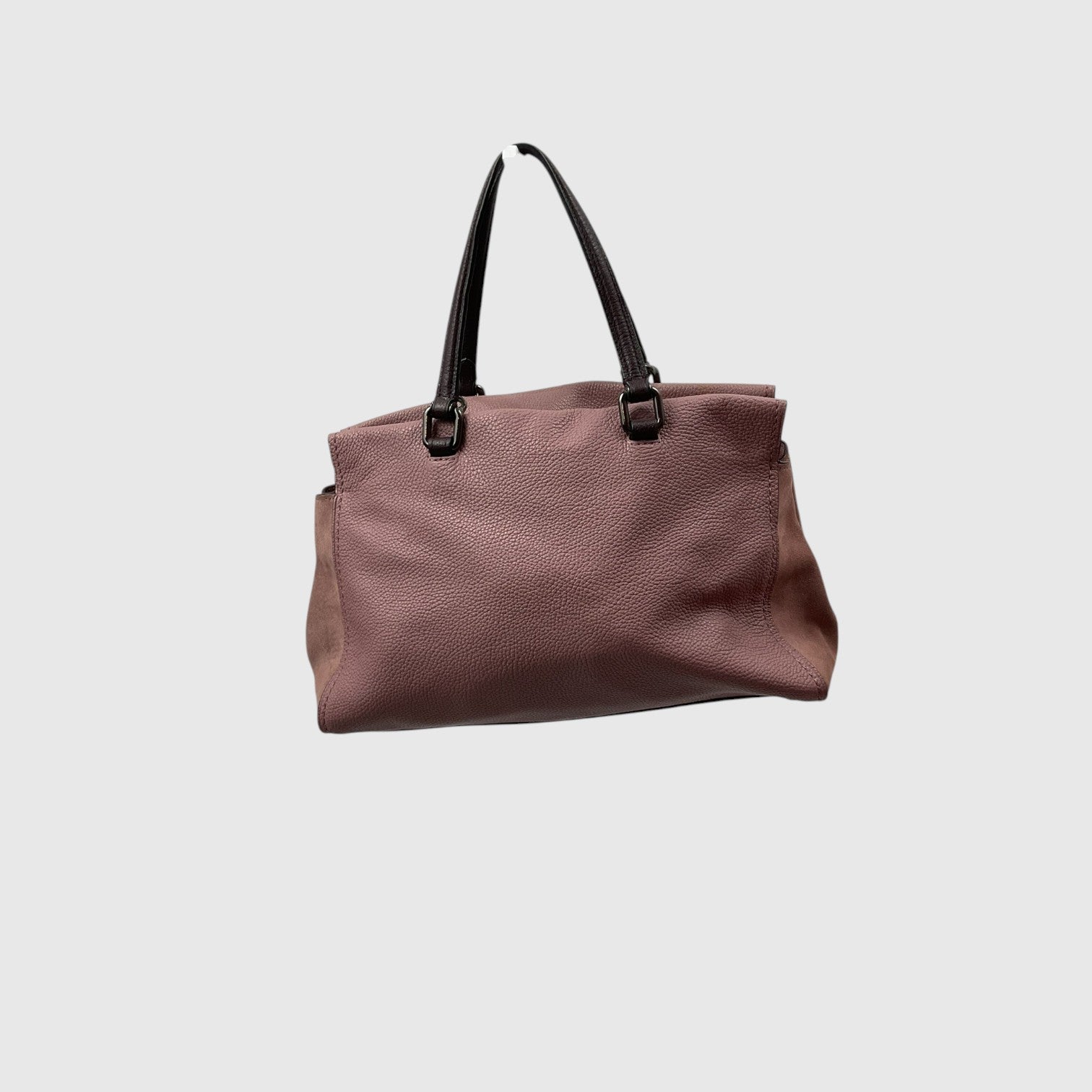 A dusty rose pebbled leather tote bag with black shoulder straps, shown against a solid light gray background.