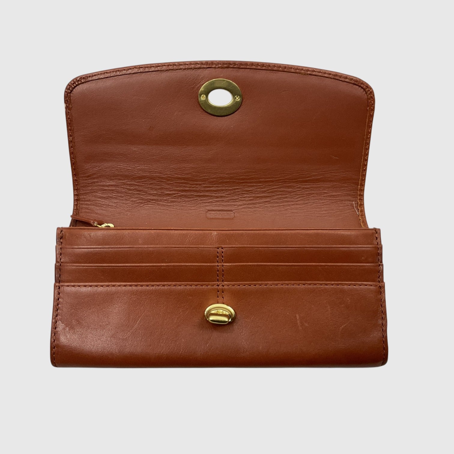 A brown leather wallet shown open against a light gray background, featuring gold-tone metal hardware and multiple card slots.