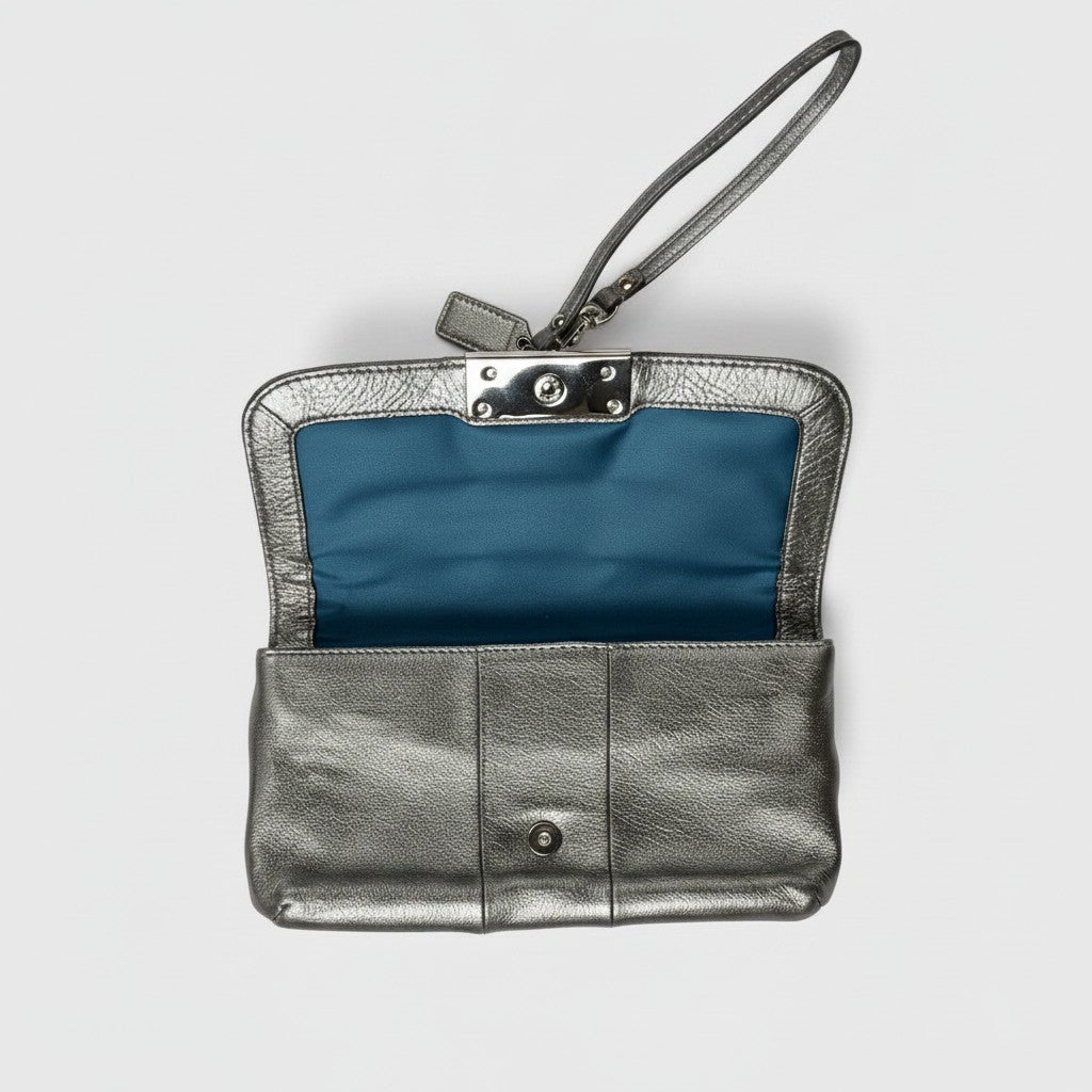 A metallic silver leather wristlet clutch with a blue satin lining, shown open against a light gray background.
