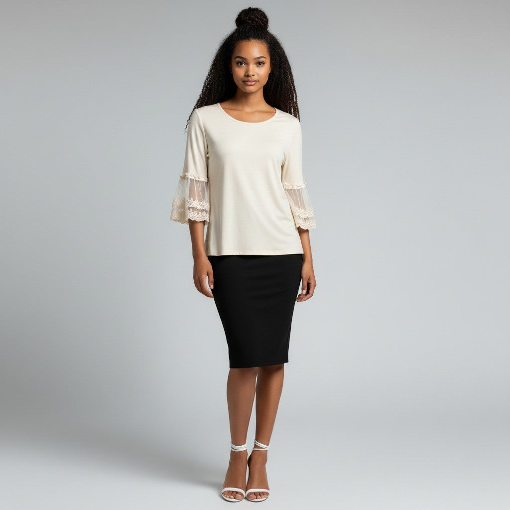 A woman modeling a cream-colored blouse with sheer ruffled 3/4 sleeves and a black knee-length pencil skirt, paired with white heeled sandals, against a light gray studio background.