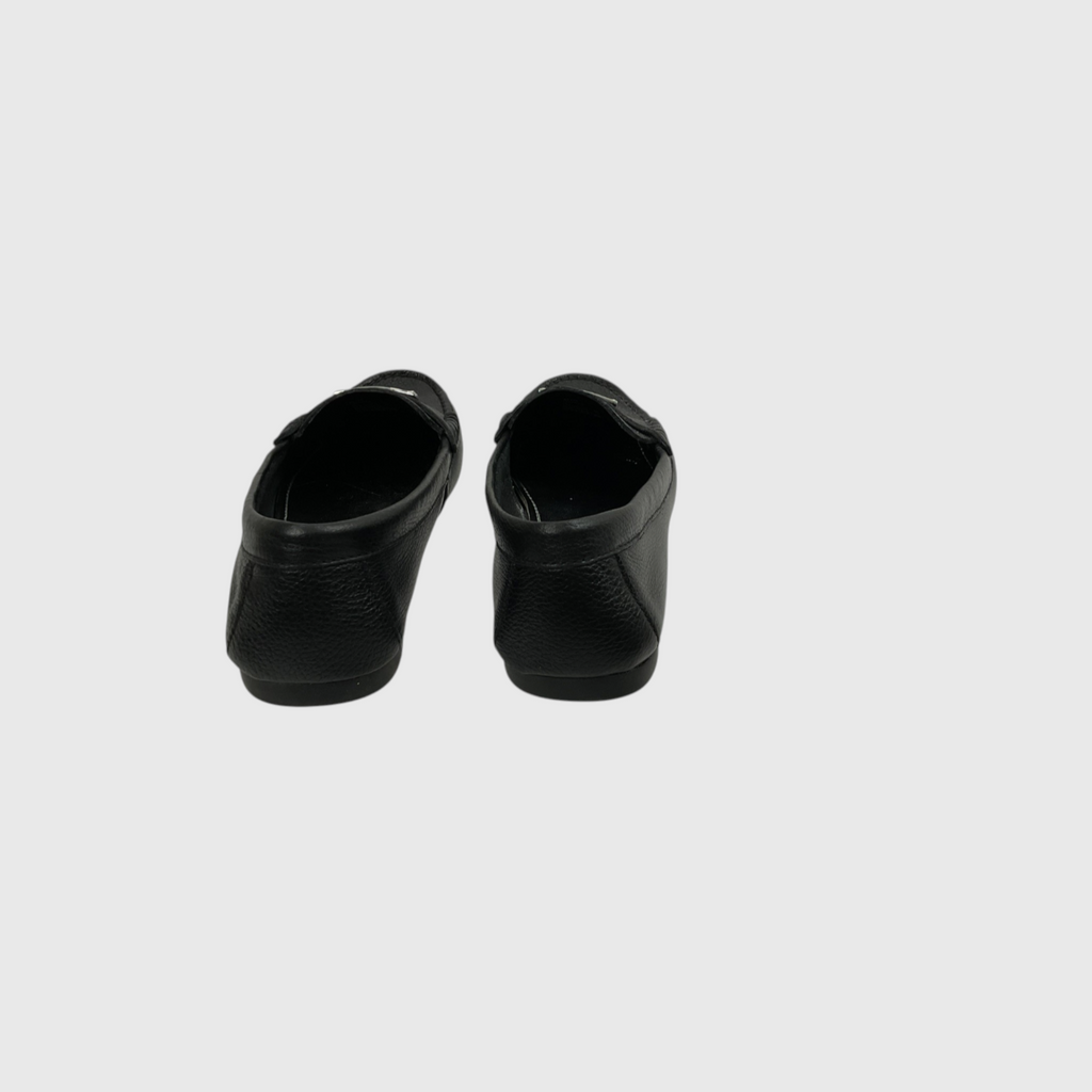 A pair of black leather slip-on shoes shown from the back against a light gray background.