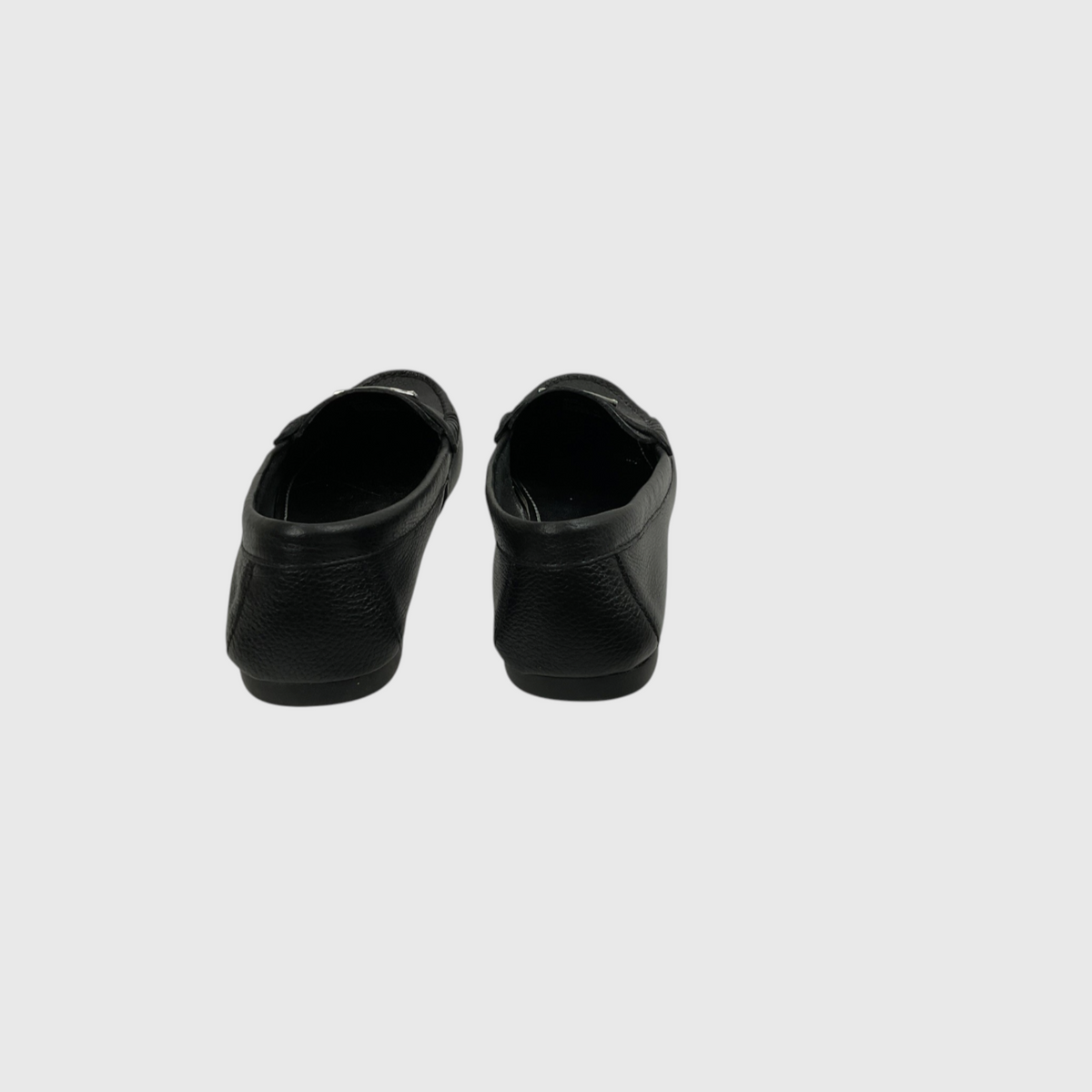 A pair of black leather slip-on shoes shown from the back against a light gray background.