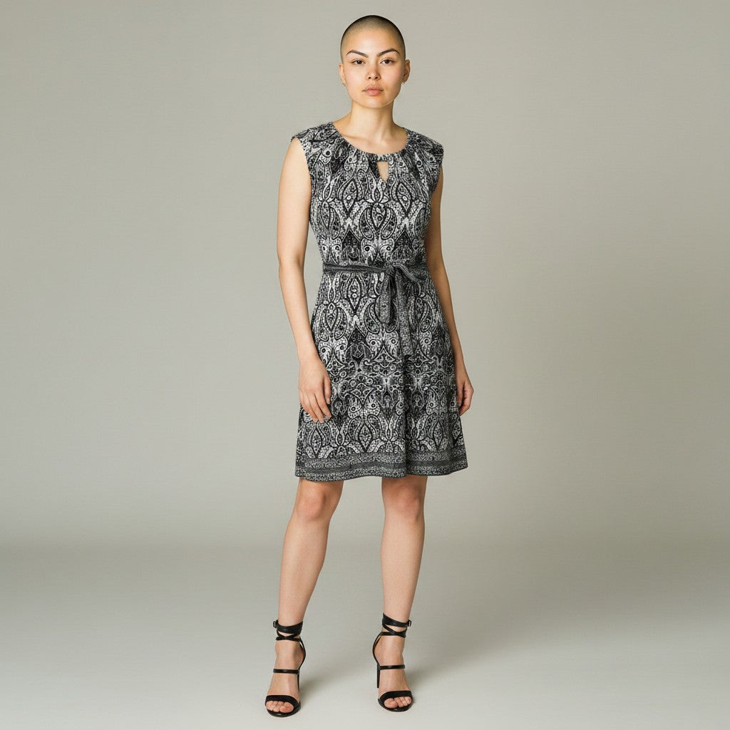 A woman with a floral dress and black heels on a light gray background