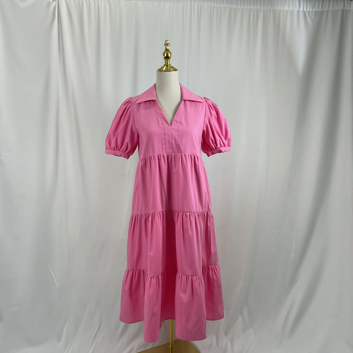 A pink dress o a light gray studio background
