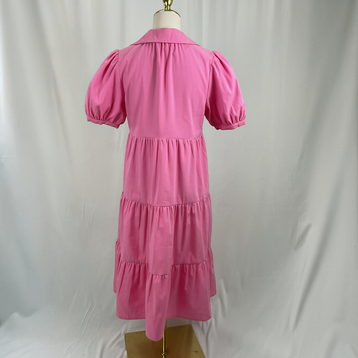 A pink dress o a light gray studio background
