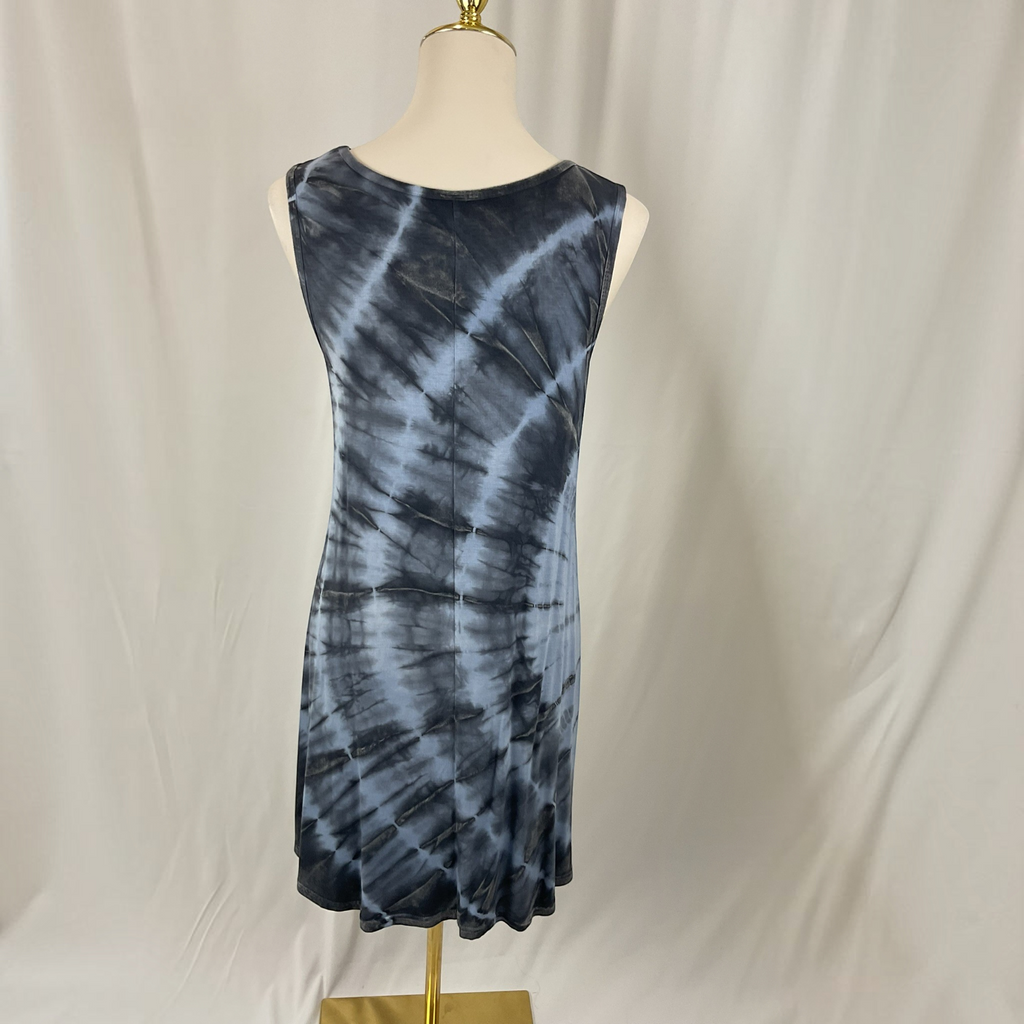 A sleeveless A-line dress with a blue and gray spiral tie-dye pattern, displayed on a cream mannequin torso with a gold stand against a white fabric backdrop.