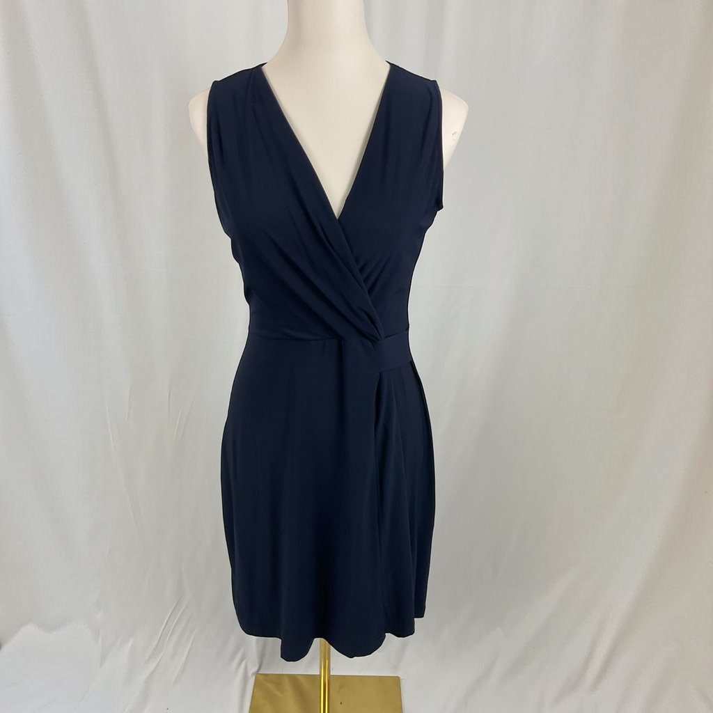 A sleeveless dark navy blue wrap-style dress displayed on a white mannequin torso against a white draped fabric backdrop.