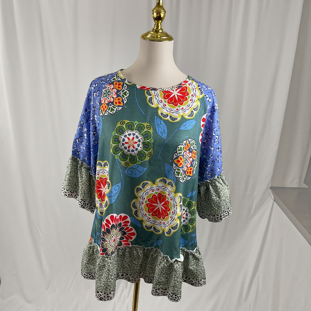 A woman wearing a floral shirt, white jeans, white sandals on a studio gray background,