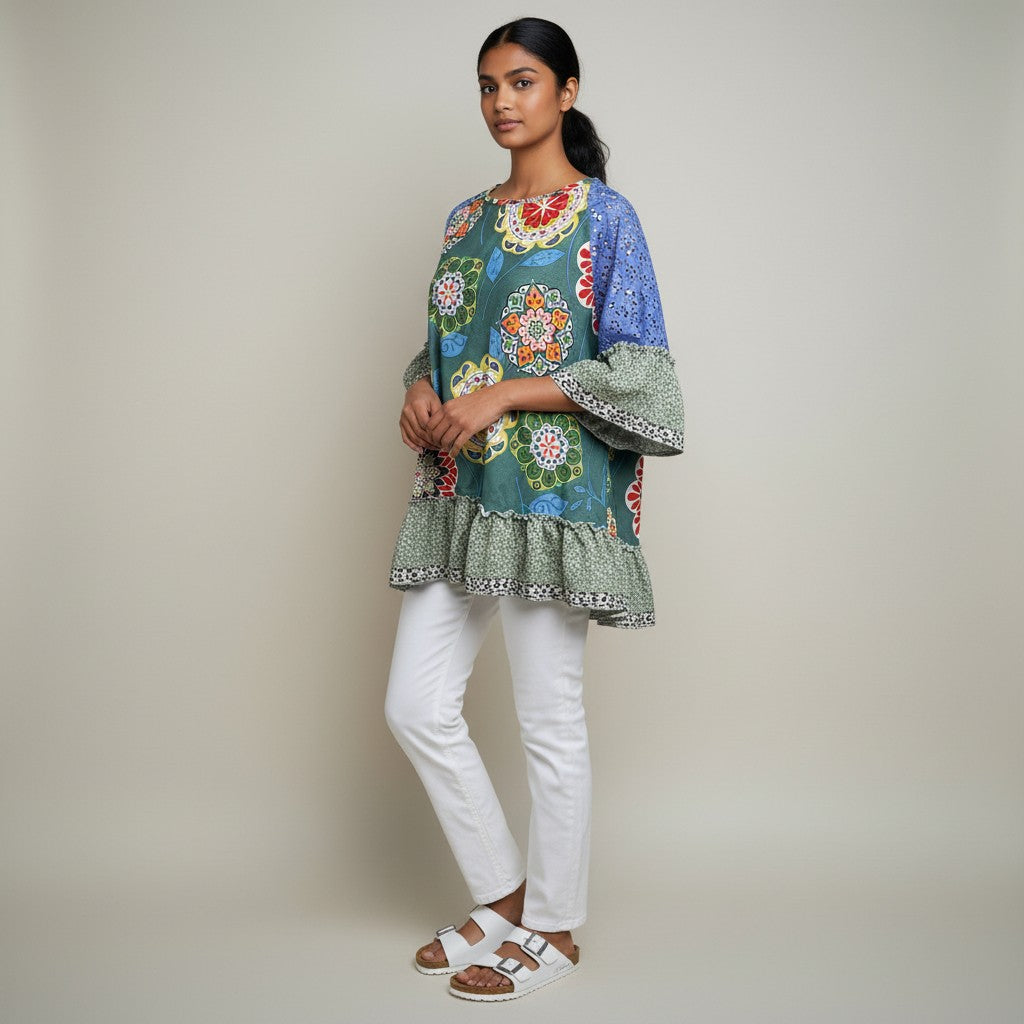 A woman wearing a floral shirt, white jeans, white sandals on a studio gray background,