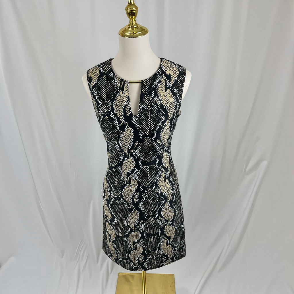 A sleeveless black and beige snakeskin print dress displayed on a white mannequin with a gold neck cap and stand, set against a white draped fabric backdrop.