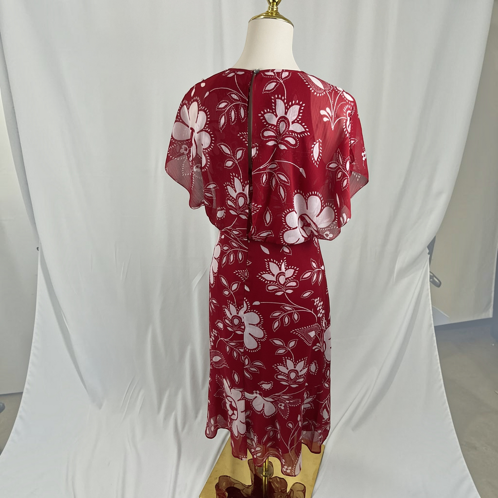 A red midi dress with a white floral pattern, displayed on a mannequin from the back. The dress features short flutter sleeves and a fitted waist, set against a white studio backdrop.