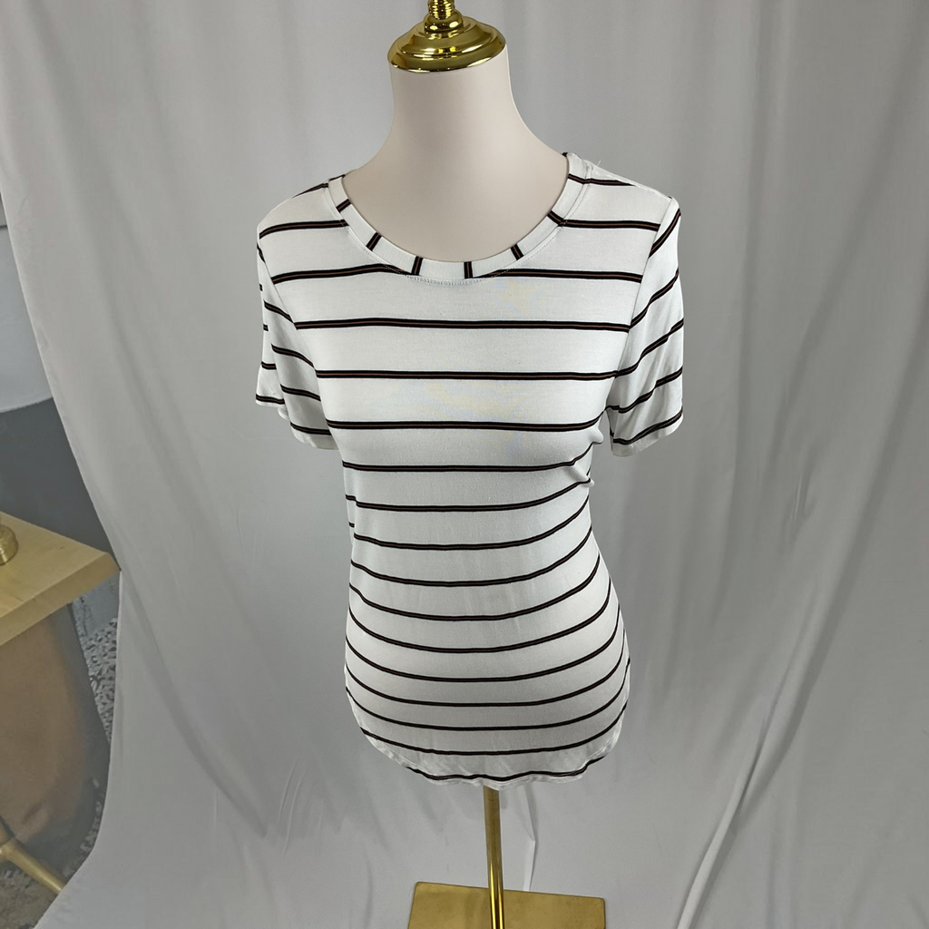 A white short-sleeve crewneck t-shirt with thin black horizontal stripes, displayed on a cream-colored mannequin dress form with a gold stand against a white fabric backdrop.