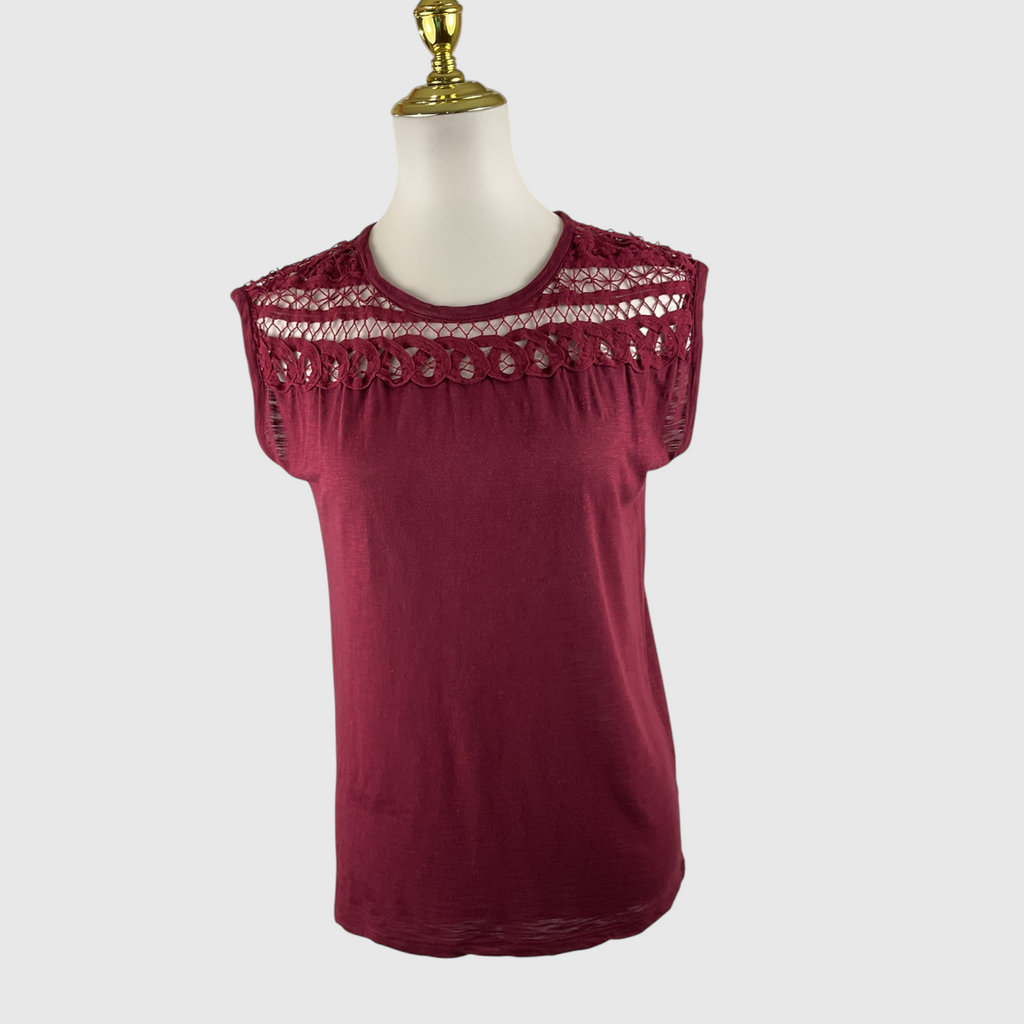 A sleeveless burgundy top with a decorative lace and crochet yoke, displayed on a white mannequin torso with a gold neck cap against a light gray background.