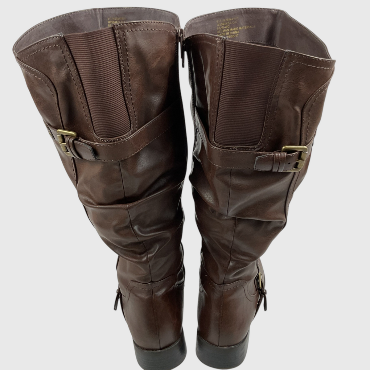 A pair of dark brown leather knee-high boots with side buckle straps and elasticated upper panels, shown from the back against a light gray background.