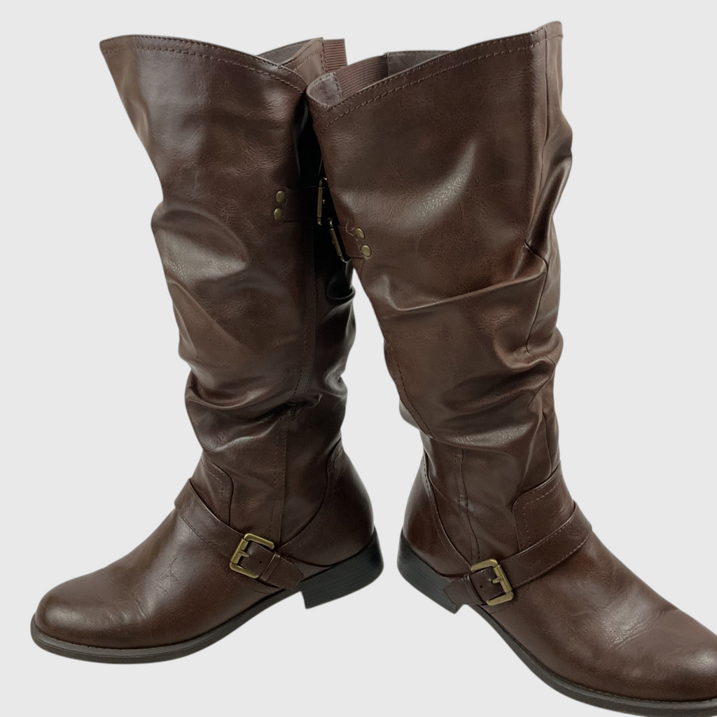 A pair of dark brown faux-leather slouchy knee-high boots with buckle straps on the sides, shown against a plain light gray background.