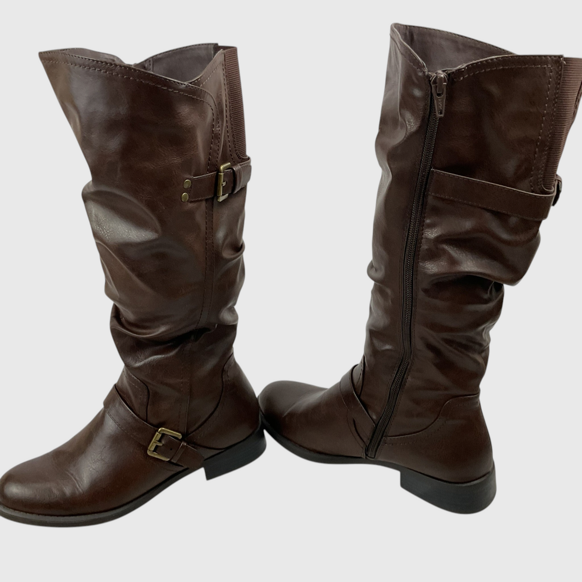 A pair of dark brown slouchy knee-high boots with buckle straps and a side zipper, shown against a plain light gray background.