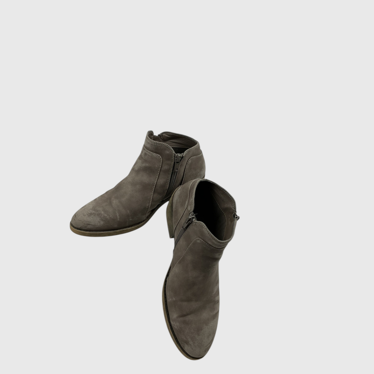 A pair of women's ankle boots in a distressed taupe-brown suede, shown from a high-angle perspective against a light gray background.