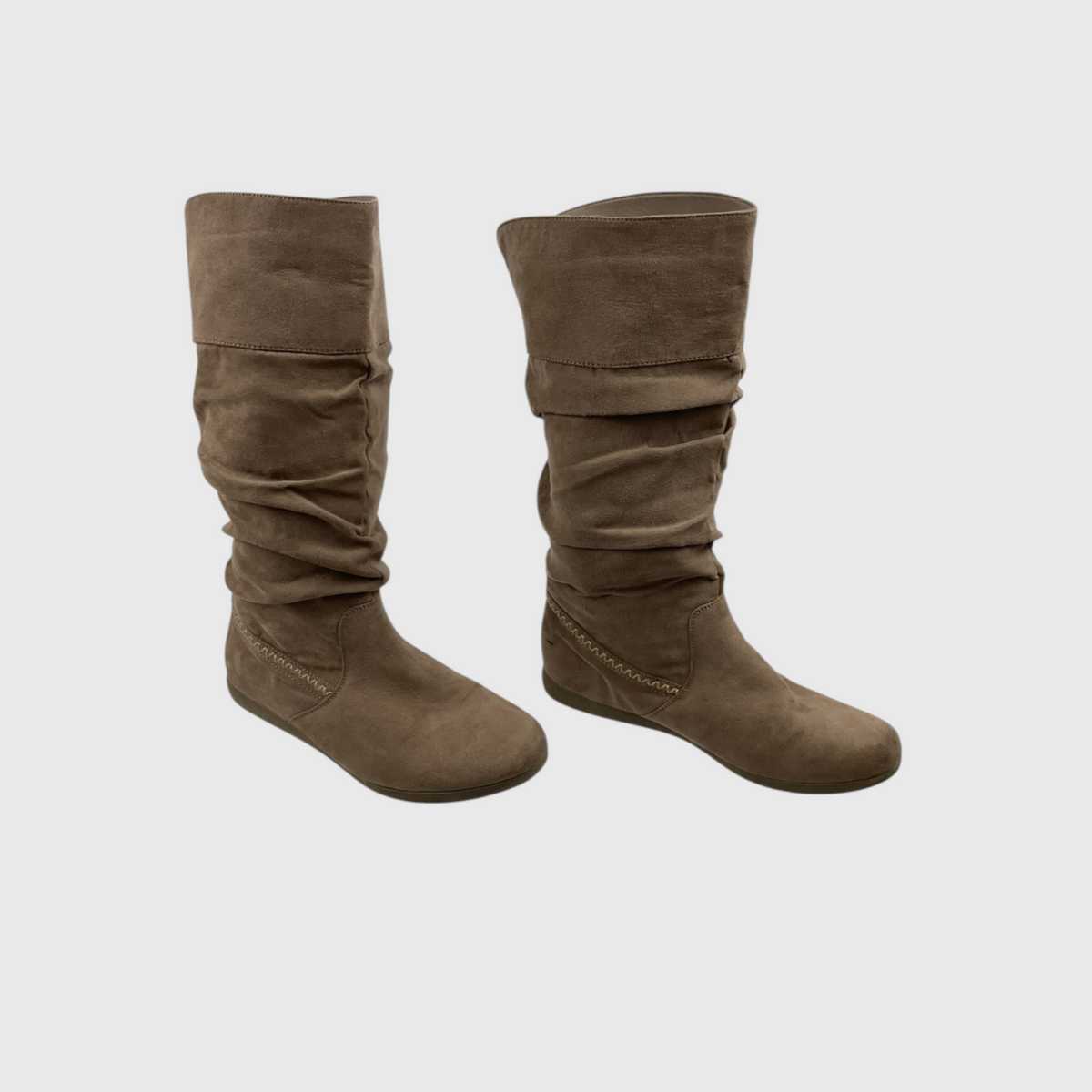 A pair of mid-calf brown suede boots with a slouchy, gathered design and flat soles, shown against a light gray background.