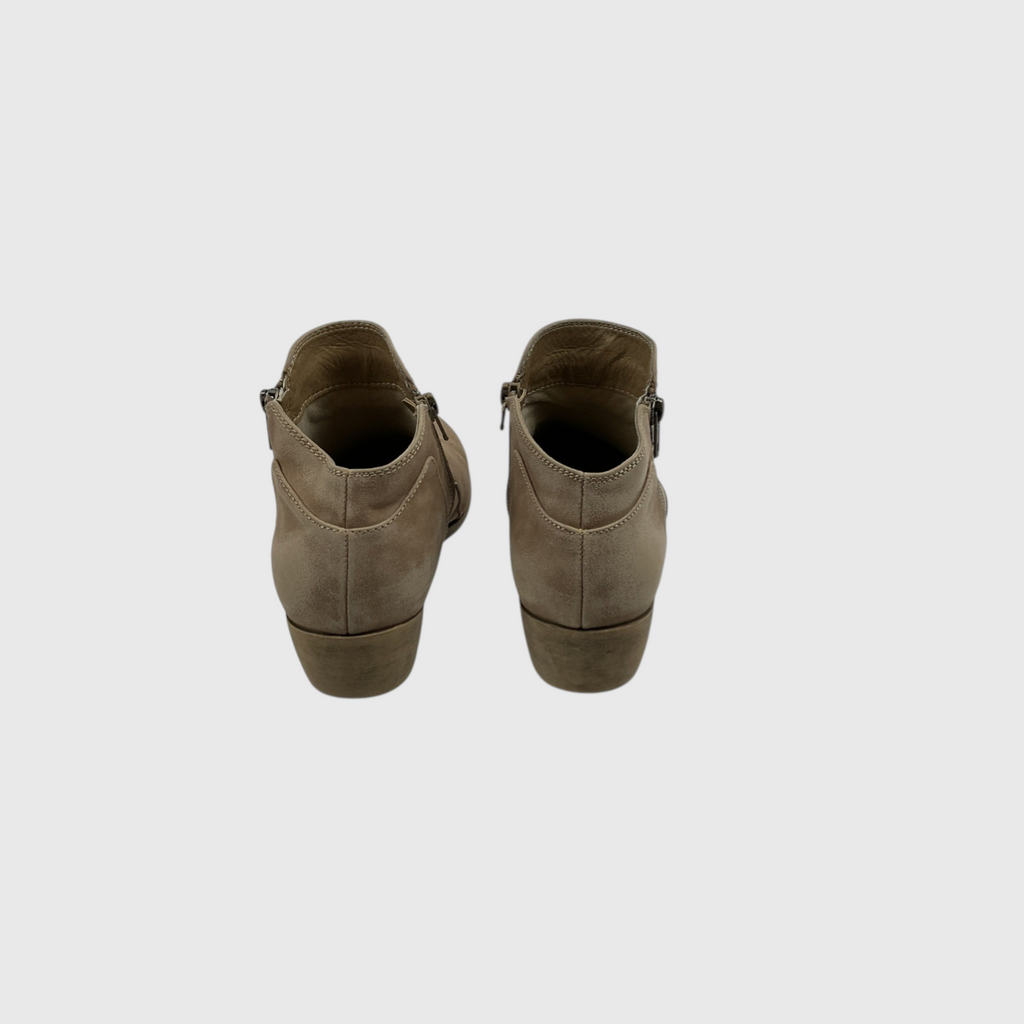 A pair of taupe-brown suede ankle boots shown from the back against a light gray background.