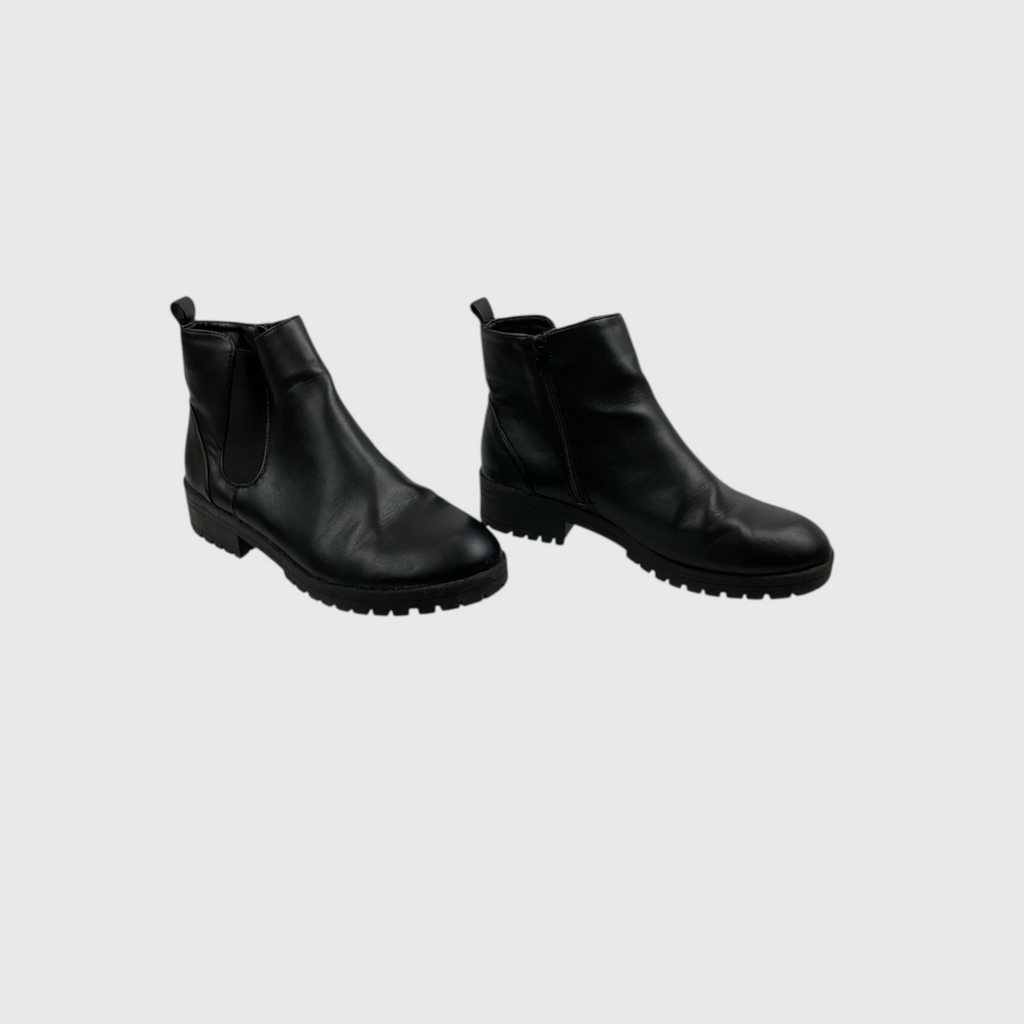 A pair of black leather Chelsea boots with elastic side panels and lug soles, shown against a solid light gray background.