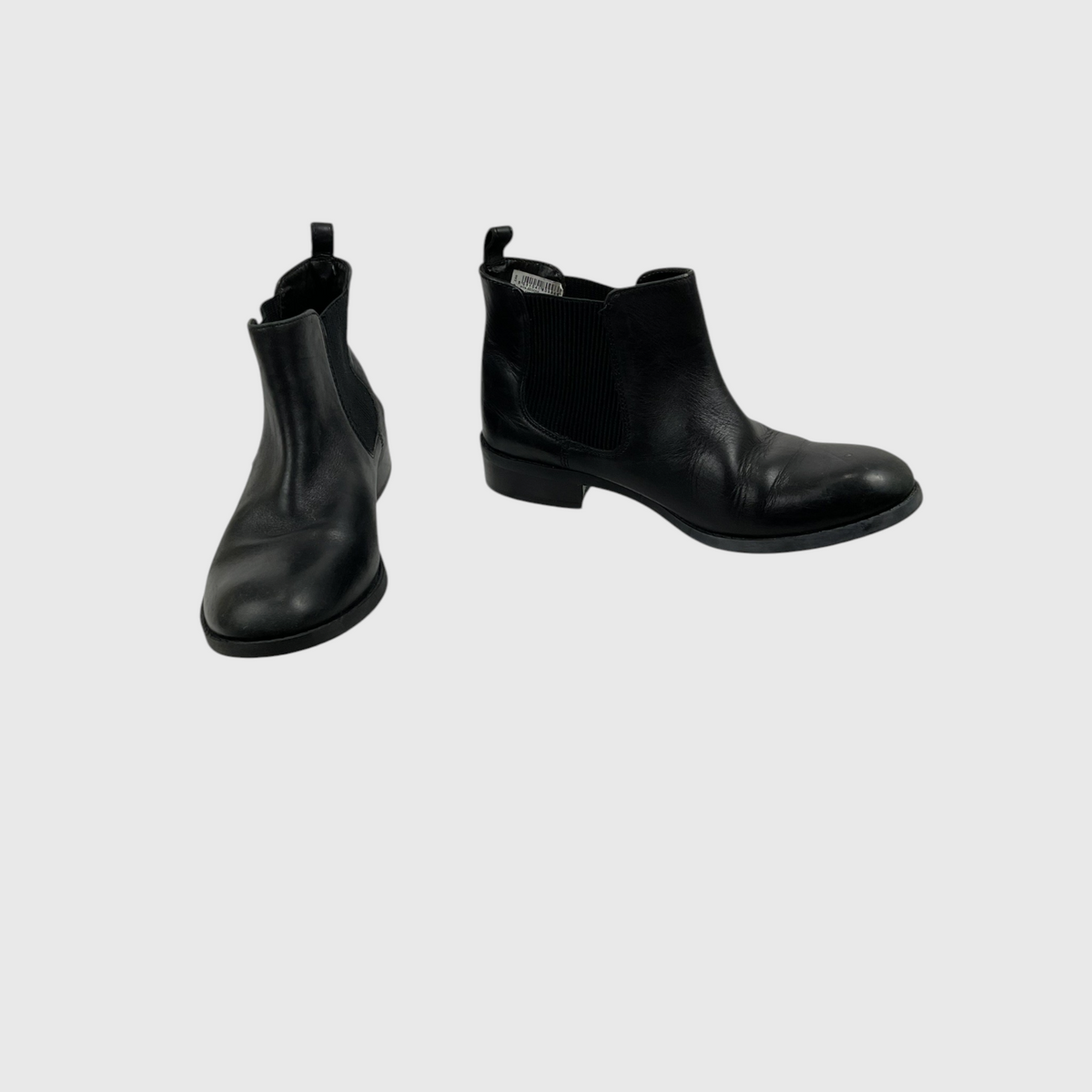 A pair of black leather Chelsea boots shown from two angles (side and front-three-quarter views) on a light gray background.