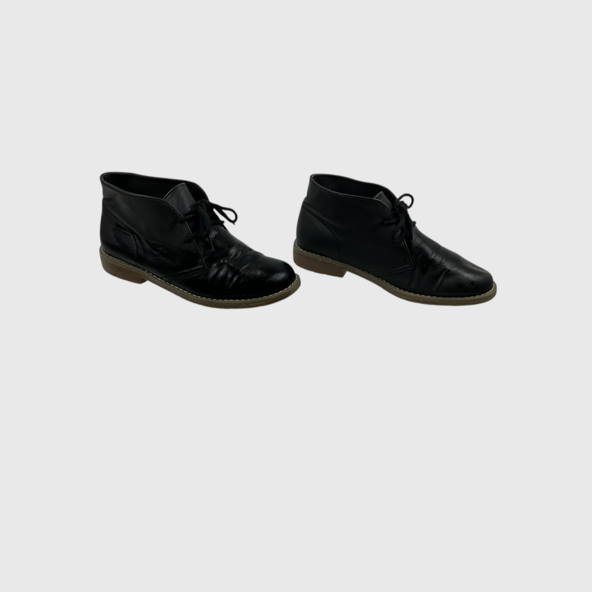 A pair of black leather lace-up ankle boots with brown soles, shown from the side against a light gray background.